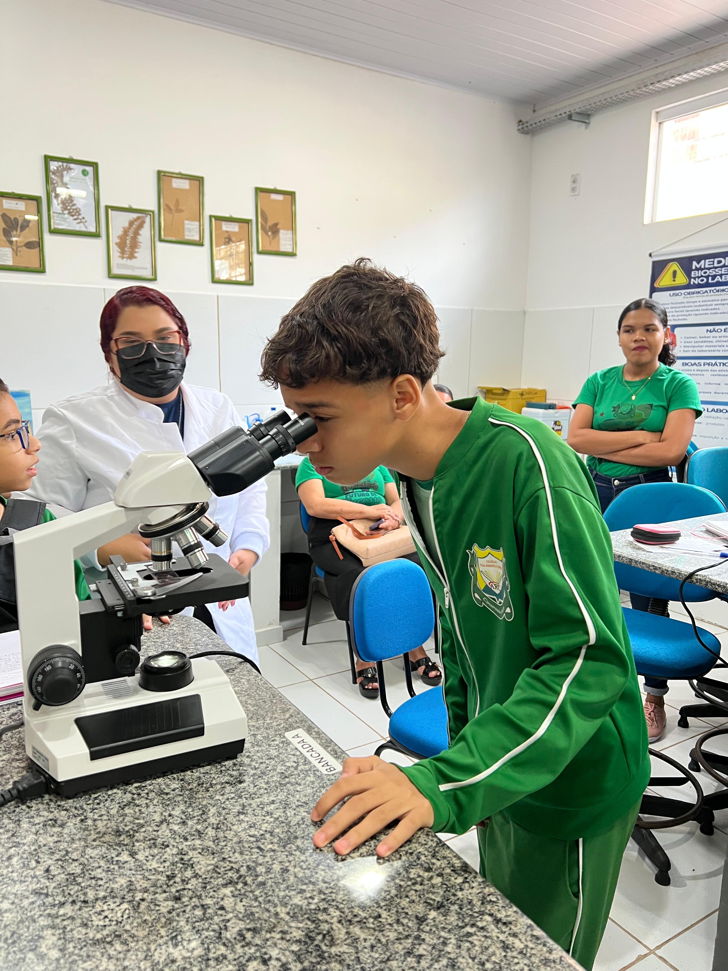 Aluno utilizando microscópio